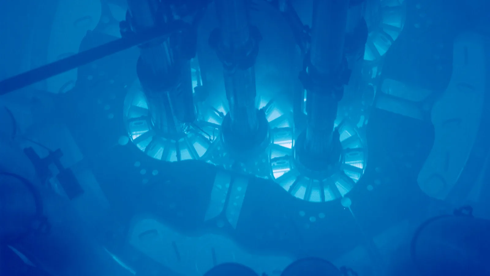 Deep blue glow around a reactor core, seen from above through water.